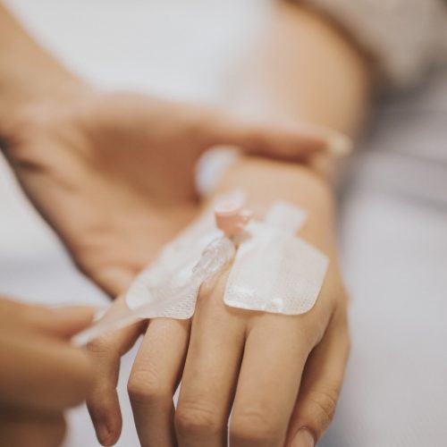 Nurse applying an IV drip to a patient